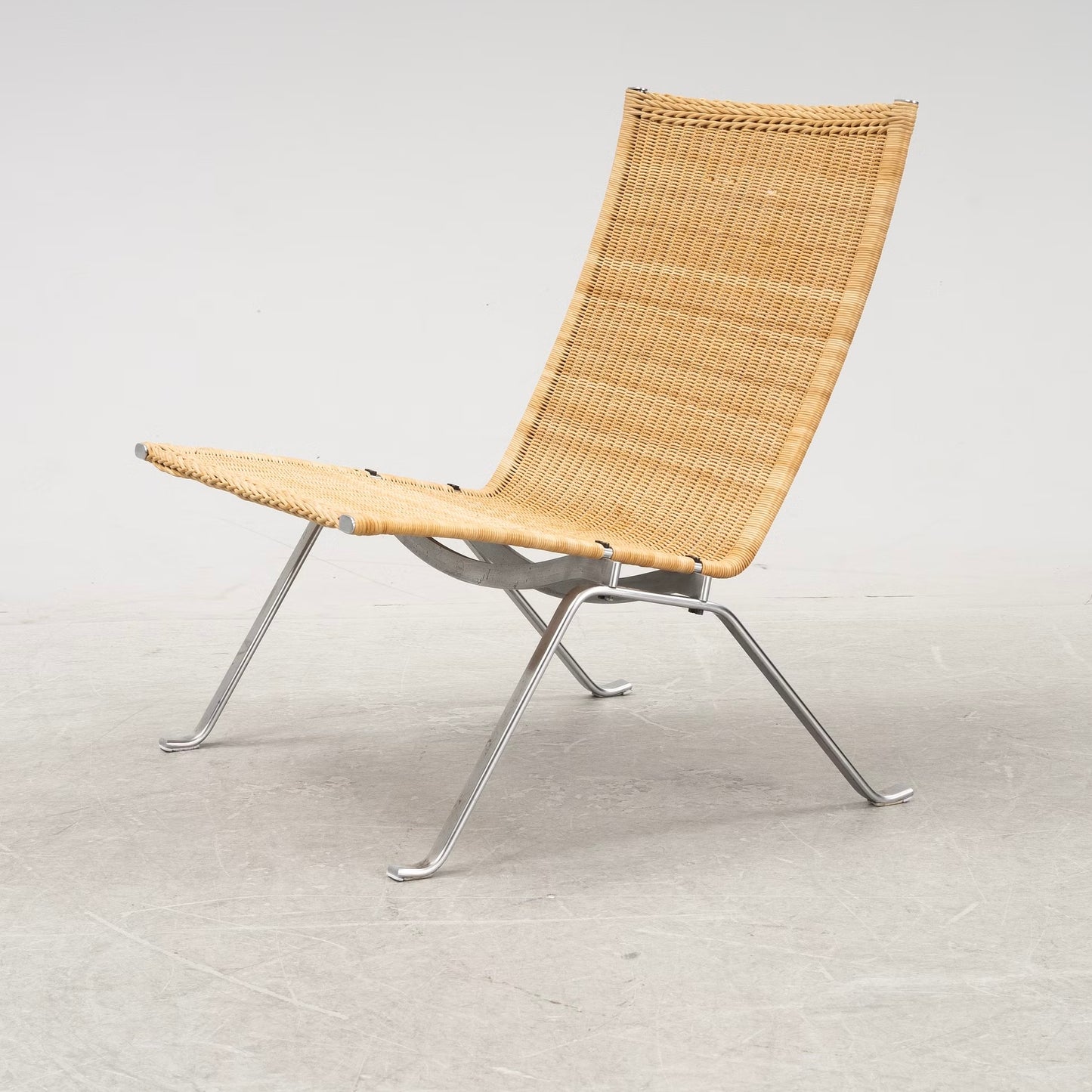 Woven chair with metal frame on a light gray background