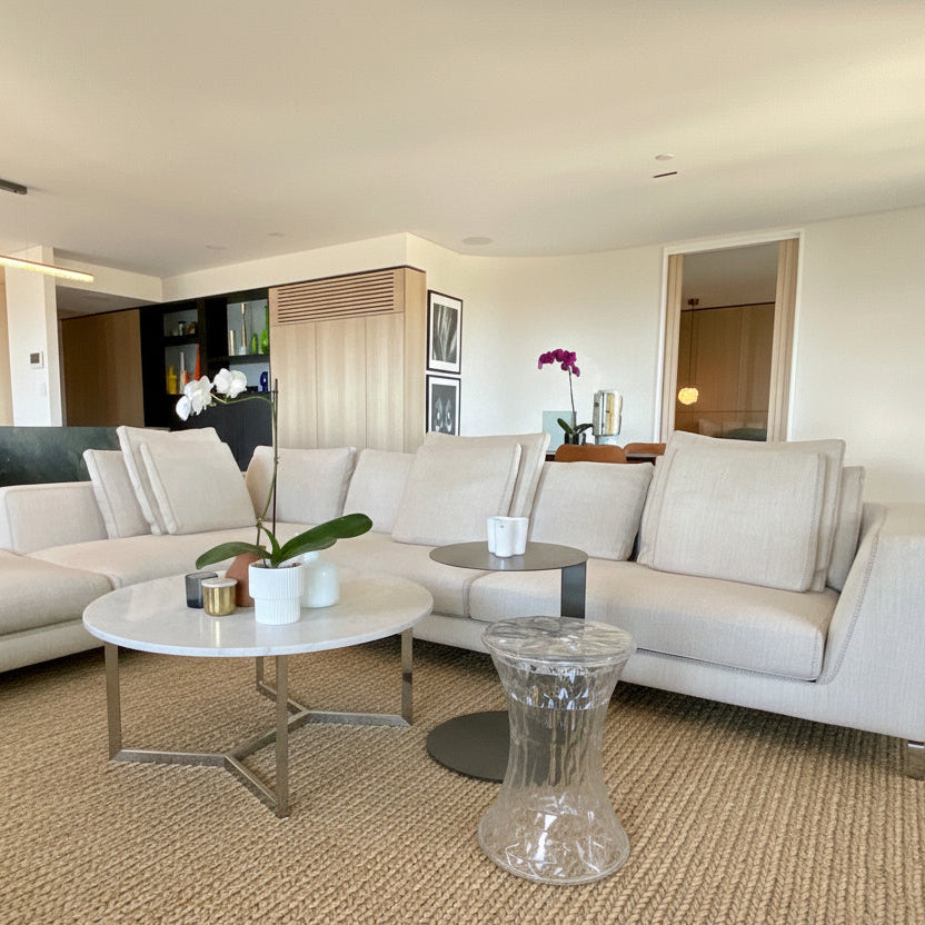 Modern living room with a white sectional sofa, coffee table, and decorative items.