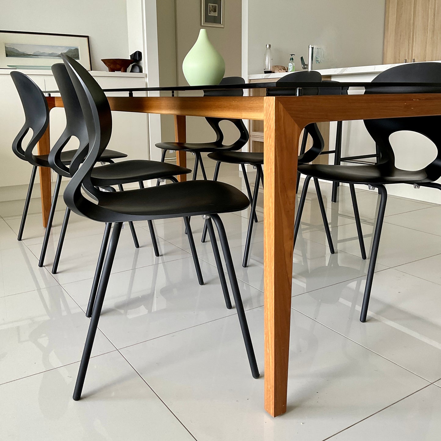 Dining table with black chairs in a modern kitchen setting